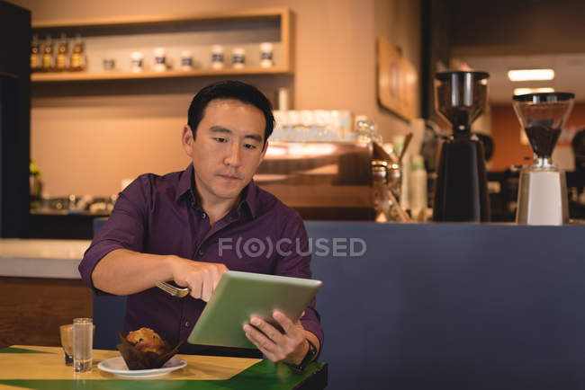 Homem chinês usando tablet digital no café — Fotografia de Stock