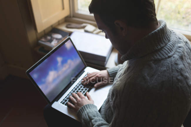 Уважний чоловік використовує ноутбук вдома — стокове фото