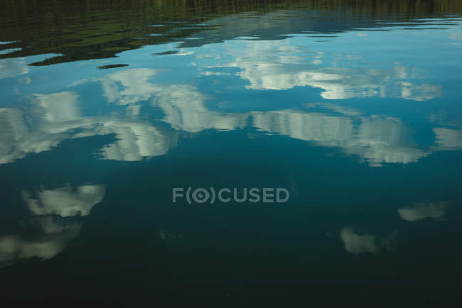 Lac avec reflet du ciel et des nuages par une journée ensoleillée — Photo de stock