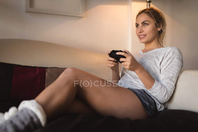 Женщина играет в видеоигры в гостиной дома — стоковое фото