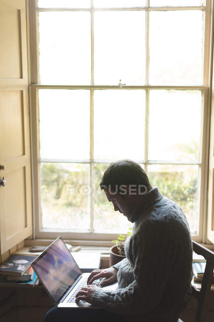 Aufmerksamer Mann benutzt Laptop zu Hause — Stockfoto