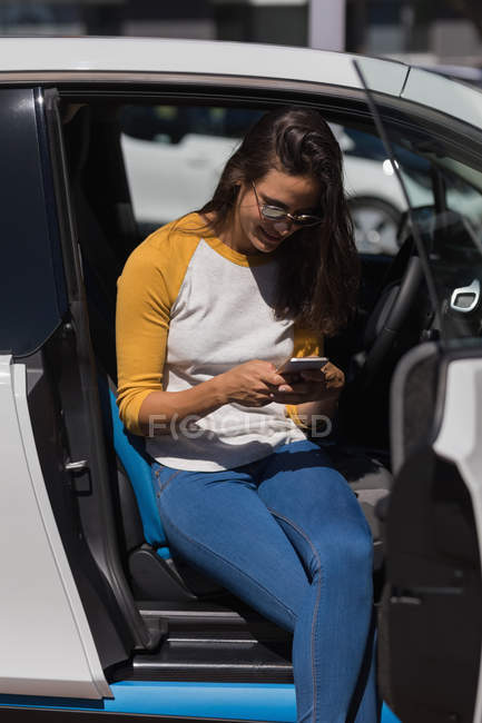 Mulher bonita usando telefone celular em um carro — Fotografia de Stock