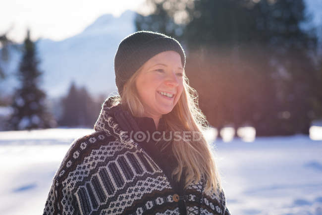 Mulher sorridente em pé na paisagem coberta de neve — Fotografia de Stock