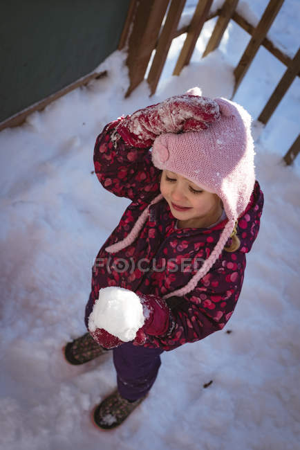 High angle of cute girl holding snow during winter — Stock Photo