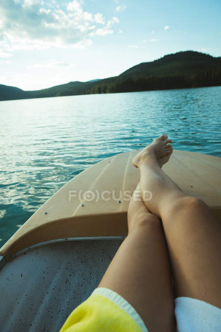 Partie basse de l'homme se détendre sur le bateau dans un lac — Photo de stock