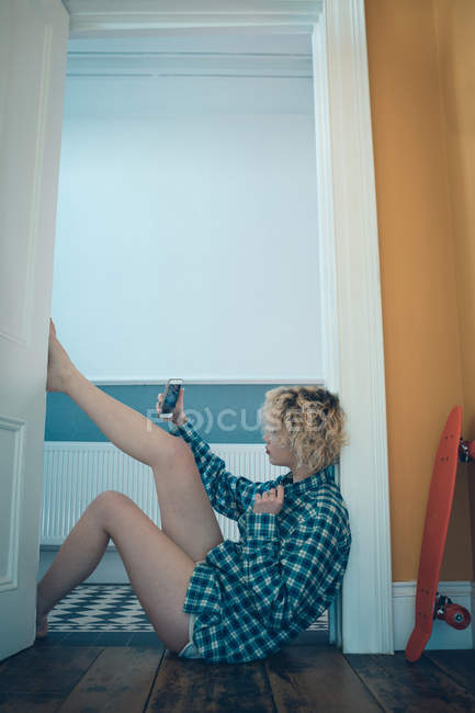 Frau macht Selfie mit Handy in Wohnungstür — Stockfoto