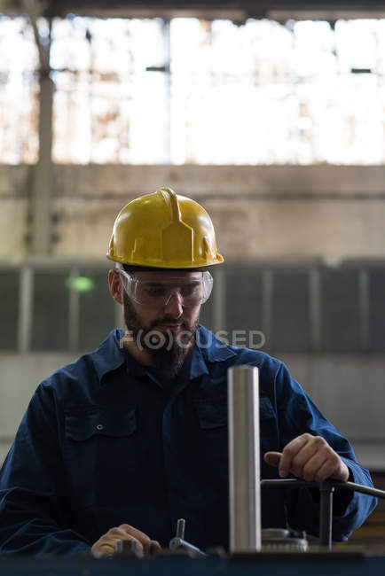 Technician in protective workwear cutting metal in industry — Stock Photo