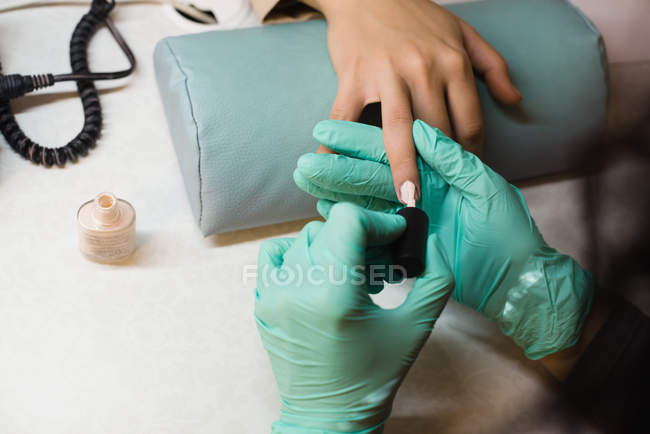 Beautician giving manicure treatment to female customer in parlour — Stock Photo