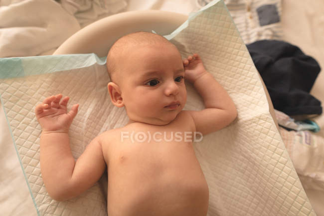 High angle view of cute little baby lying on mat at home — Stock Photo
