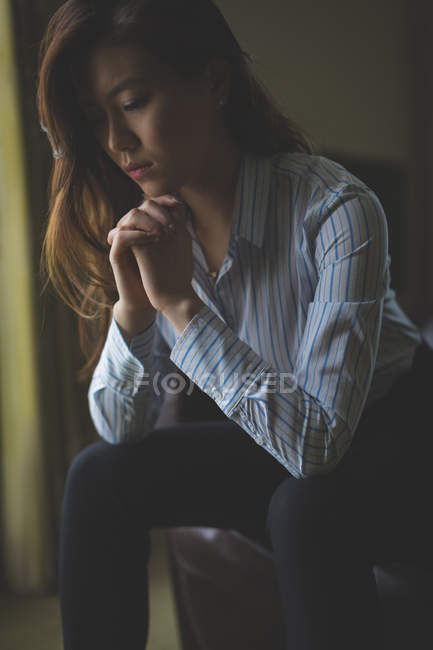 Thoughtful businesswoman sitting on armchair in hotel room — Stock Photo