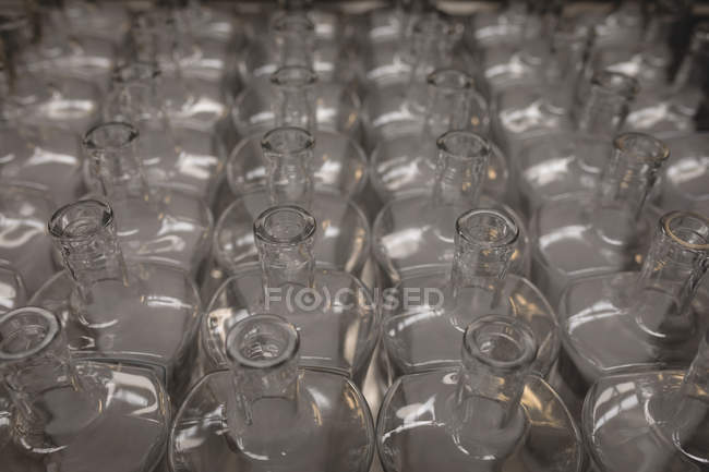 Botellas vacías mantenidas en fila en fábrica - foto de stock