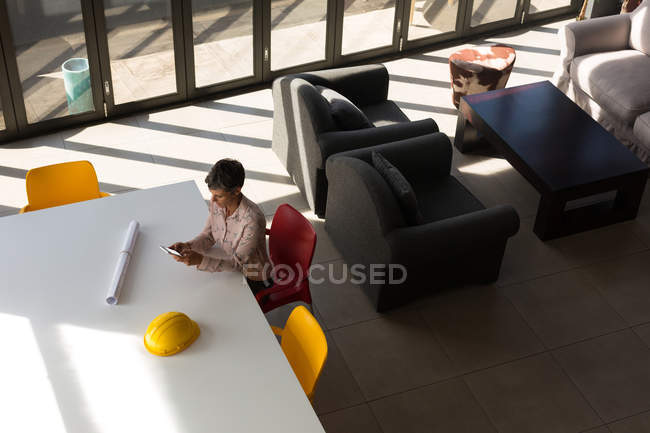 Reife Geschäftsfrau mit Handy im Büro — Stockfoto