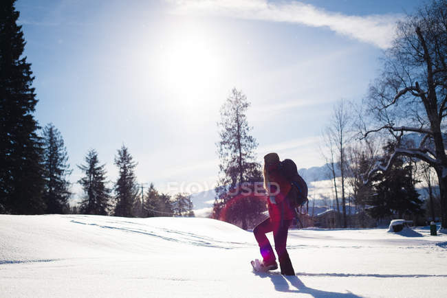 Женщина идет по снежному склону в солнечный день — стоковое фото