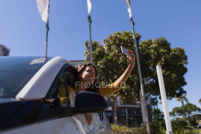 Mulher bonita tomando selfie com telefone celular em um carro — Fotografia de Stock