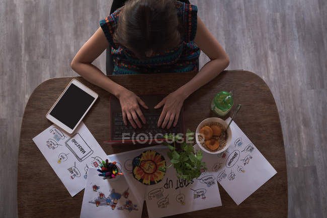 Female executive using laptop in office — Stock Photo
