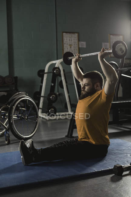 Behinderter Mann trainiert mit Langhantel in Turnhalle — Stockfoto