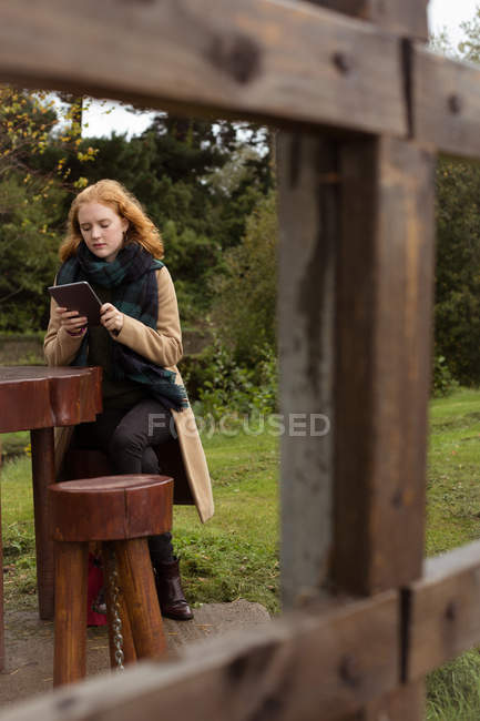 Молодая женщина, использующая цифровой планшет в парке — стоковое фото