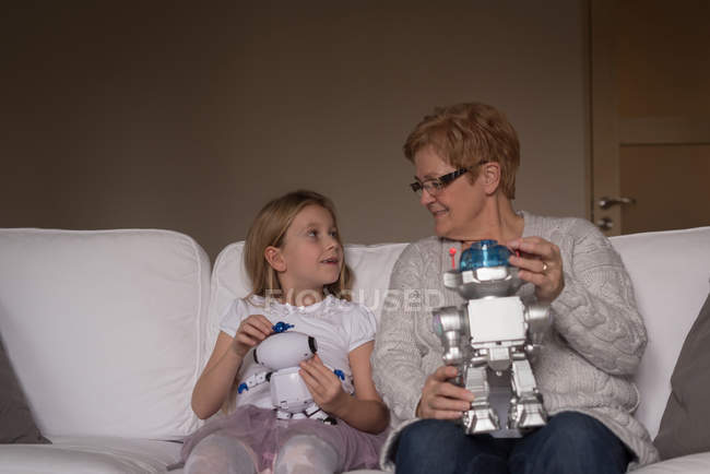 Бабуся і онука грають з іграшками у вітальні вдома — стокове фото