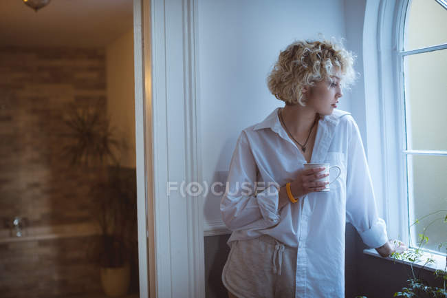 Donna premurosa che prende un caffè a casa — Foto stock