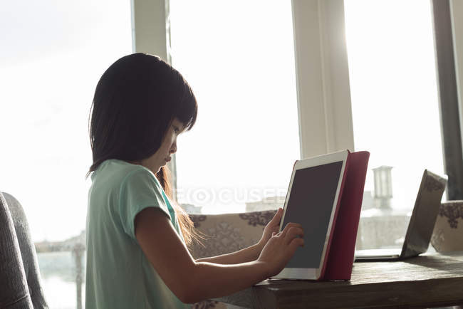 Девушка, использующая цифровой планшет дома — стоковое фото