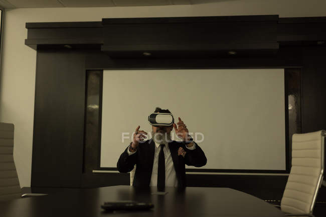 Business executive using virtual reality headset in conference room — Stock Photo
