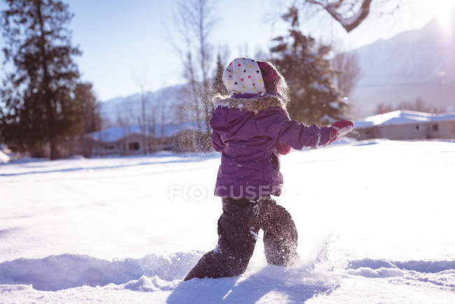 Menina despreocupada andando na neve durante o inverno — Fotografia de Stock