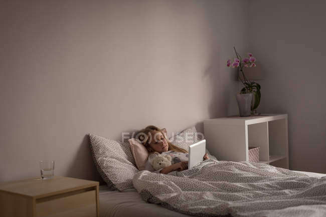 Mädchen benutzt digitales Tablet zu Hause im Schlafzimmer — Stockfoto