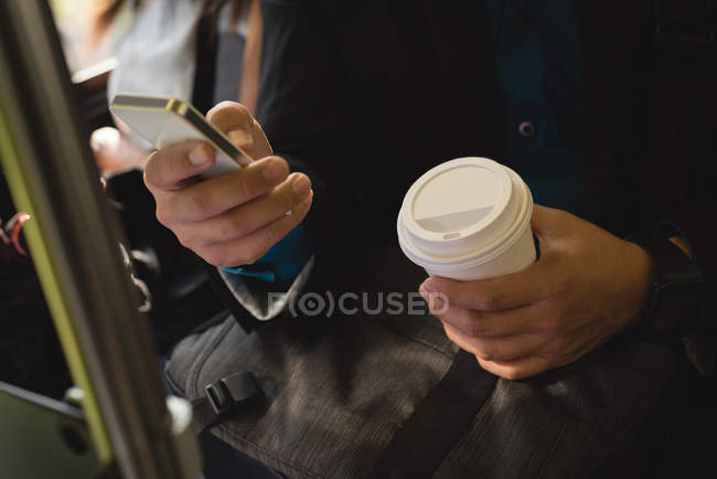 Seção média do homem usando o telefone celular no ônibus — Fotografia de Stock