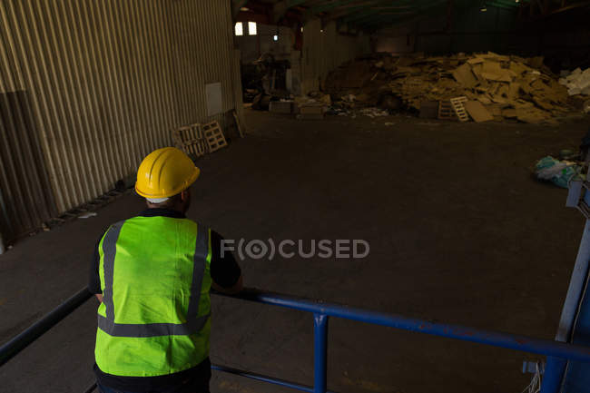 Vista posteriore del lavoratore appoggiato alle ringhiere nel cantiere di demolizione — Foto stock