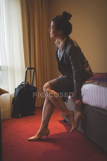 Mulher de negócios tirando os sapatos em um quarto de hotel — Fotografia de Stock