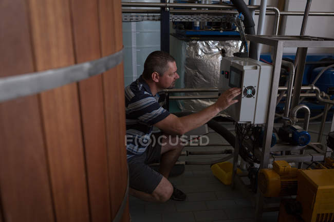 Máquina operadora masculina en fábrica de ginebra - foto de stock