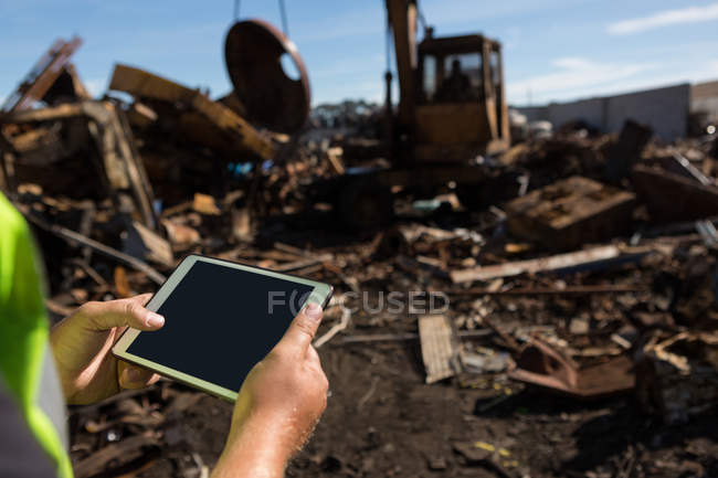 Primer plano del trabajador que sostiene la tableta digital en el desguace - foto de stock