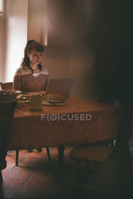 Schöne Frau mit Laptop zu Hause — Stockfoto