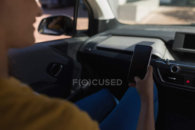 Mittelteil der Frau mit Handy im Auto — Stockfoto
