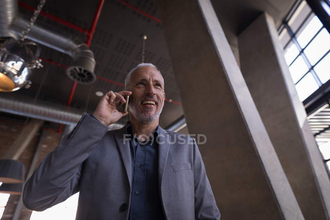 Businessman talking on mobile phone in the hotel — Stock Photo