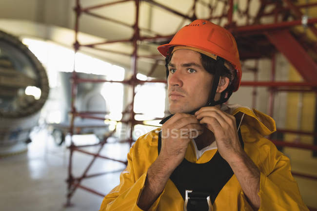 Jeune travailleur masculin portant un casque dur à la station solaire — Photo de stock