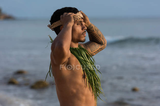 Мужчина-исполнитель стоит на пляже в мягком свете — стоковое фото