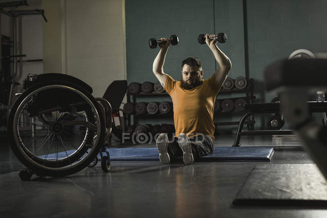 Behinderter Mann hebt Hanteln in Turnhalle — Stockfoto