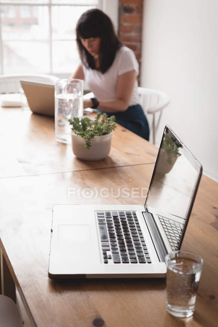 Жіночий керівник використовує ноутбук у творчому офісі — стокове фото