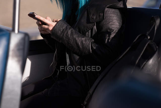 Parte média da mulher usando o telefone celular enquanto viaja no trem — Fotografia de Stock