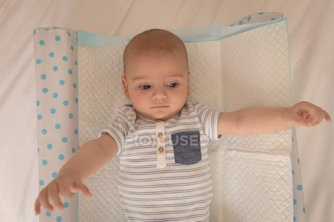 Cute little baby lying on bed at home — Stock Photo