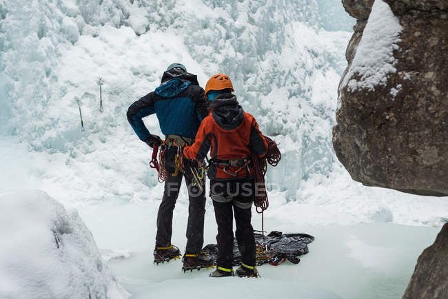Preparación de pareja para escalada en hielo durante el invierno - foto de stock