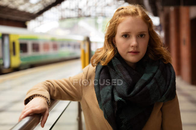 Portrait of young woman standing at railway platform — Stock Photo