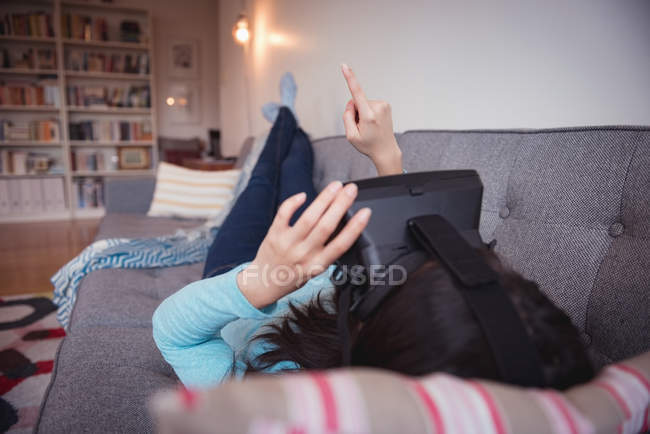 Woman using virtual reality headset in living room at home — Stock Photo