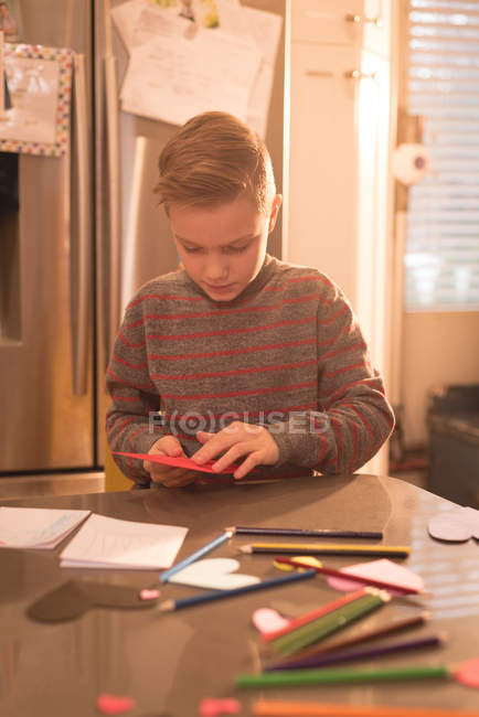 Boy preparing valentine decoration at home — Stock Photo