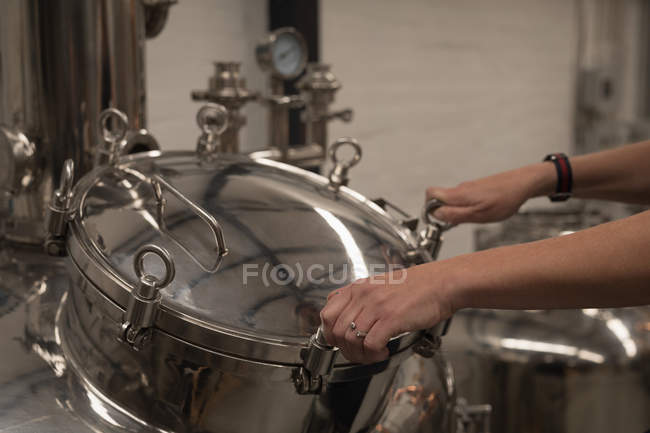 Female worker checking machine of distillery in factory — Stock Photo