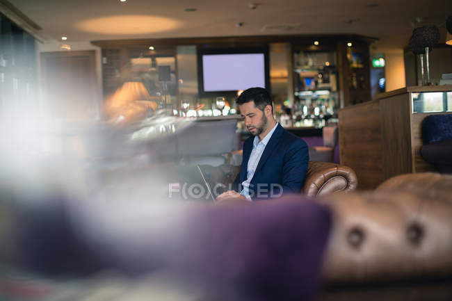 Homme d'affaires utilisant un ordinateur portable à l'hôtel — Photo de stock