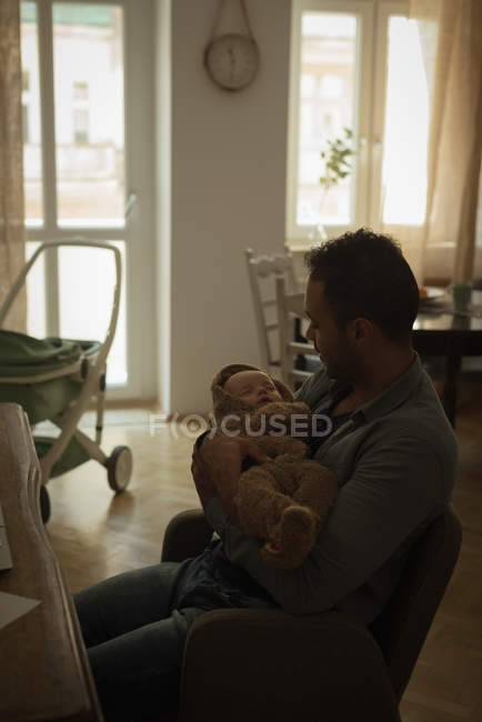Père tenant son bébé dans le salon à la maison — Photo de stock