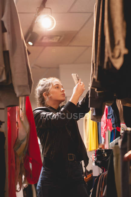 Belle fille utilisant un téléphone mobile tout en faisant du shopping dans le centre commercial — Photo de stock
