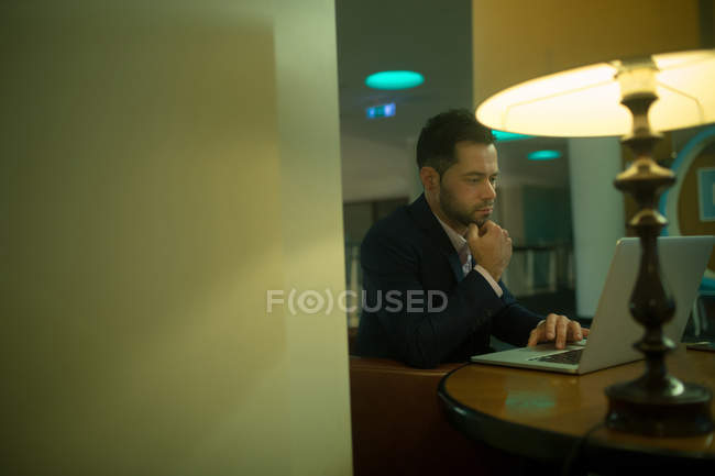 Empresario usando laptop en la habitación del hotel - foto de stock